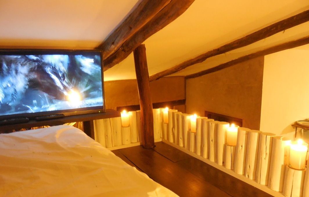 The bedroom is a loft surrounded by candles and includes a 32-inch flat screen TV with 130 satellite channels