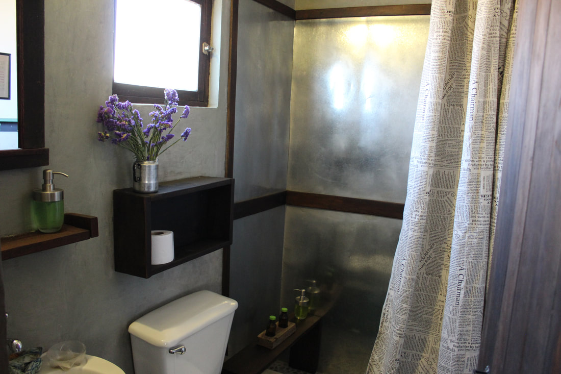 The bathroom finishings are all natural materials: cement, sheet metal and wood